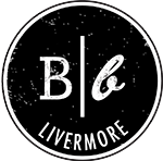 B / b (with a cursive handwriting) with livermore written below arched on a black background